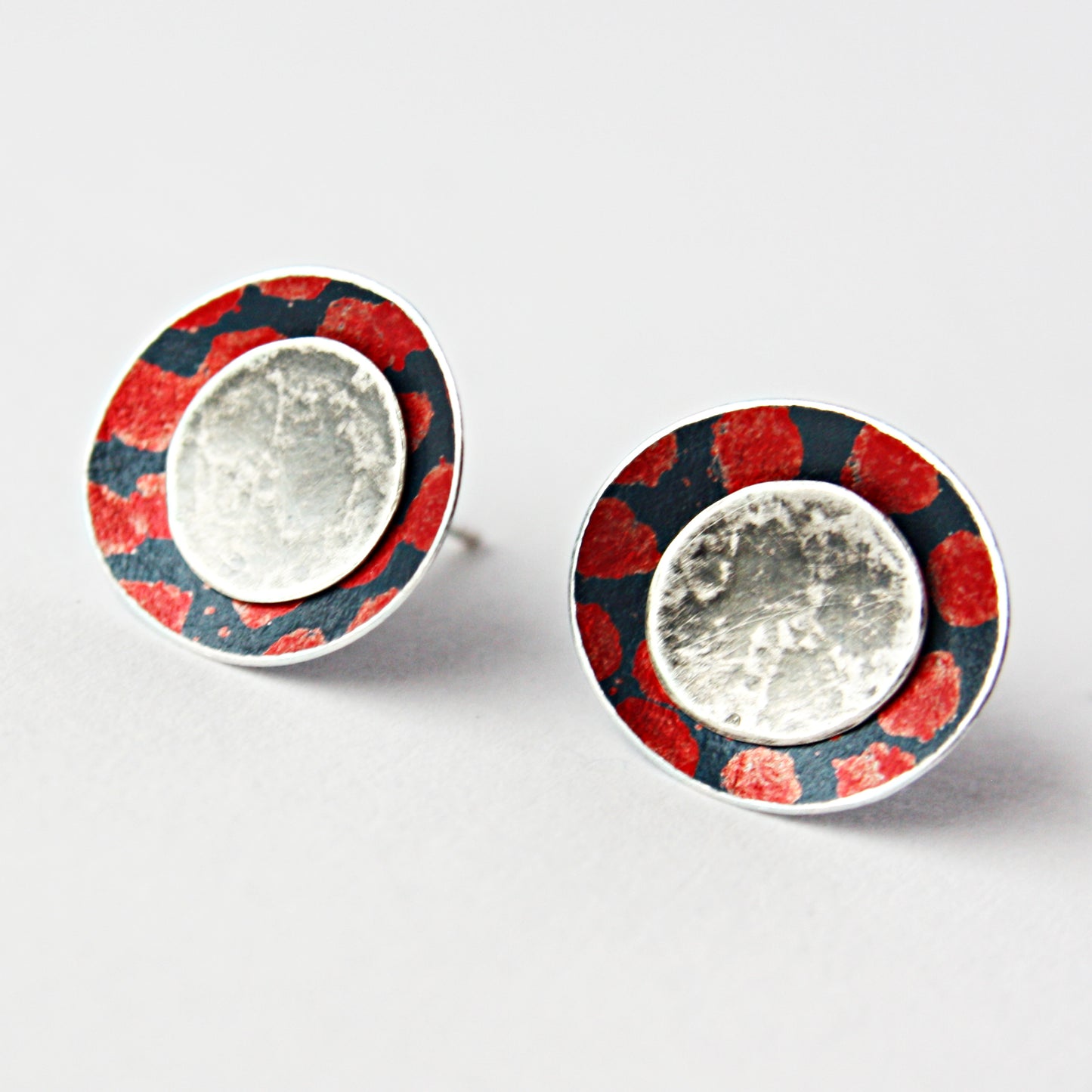 SL38 Red spotty concave oval stud earrings with textured silver centre