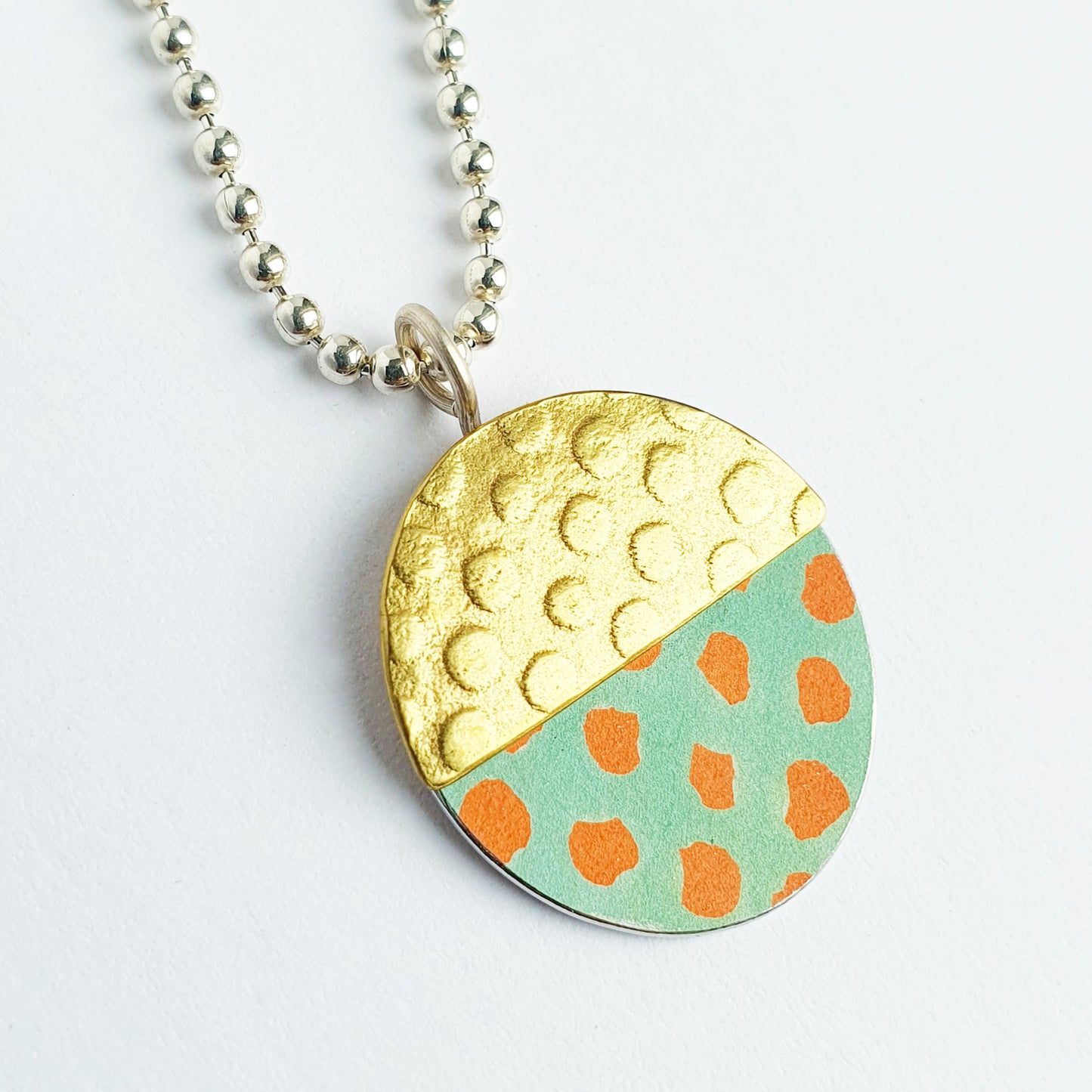 SL6  Textured brass and orange spotty oval pendant