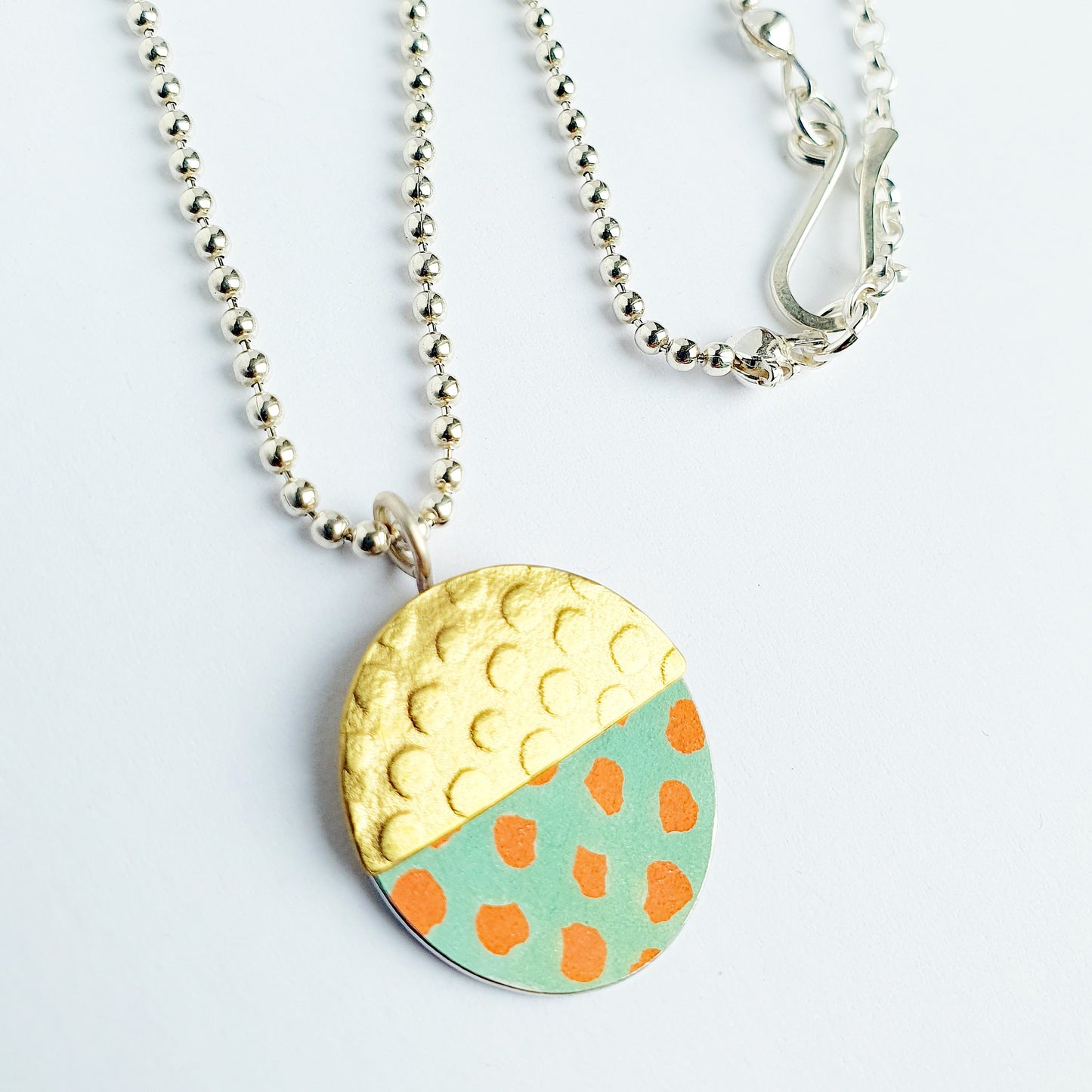 SL6  Textured brass and orange spotty oval pendant